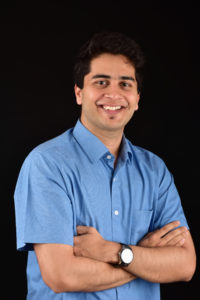 Picture of Adi Keskar with a blue shirt, black background